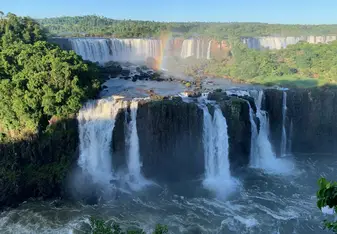 waterfall scenery with rainbow in the sky