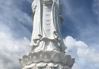 White statue of Lady Buddha standing on a lotus flower, 220 feet tall 