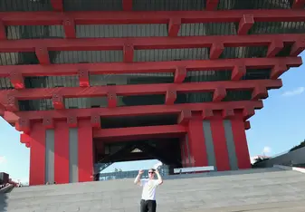 Outside the Shanghai Art Museum, a gigantic building made out of red wooden slabs interlocking in a traditional Chinese style.