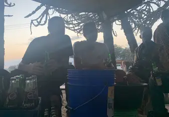 Drinking banana wine at sunset with the locals