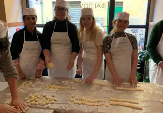 four friends making pasta together