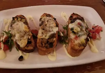 Crustini: Toasted sourdough bread, with sauteed mushrooms & vegetables, with cheese and a cream sauce