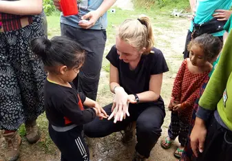 This is a picture of me teaching a little boy the 7 steps of hand washing during one of our community sessions. 