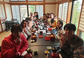 a large group of people sitting around a table in a traditional Japanese restaurant