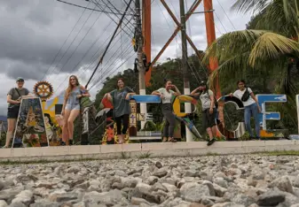 Volunteers posing with a colorful sign reading "LA MERCED"