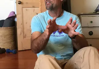 Dev sitting on the floor and gesturing