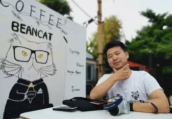 Chale posing in front of an illustration of a cat