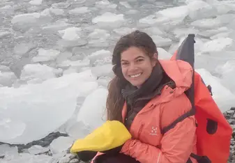 Yara posing near icy water and a seal