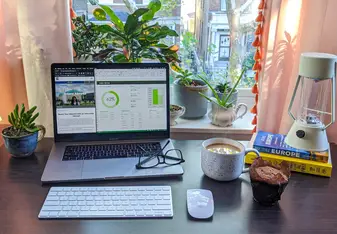 A desk with a laptop, glasses, and coffee - all ready for a day at your virtual internship!