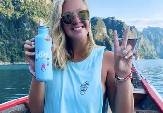 Caroline posing on a boat giving a peace sign