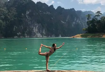 Kelly doing a yoga pose next to a body of water