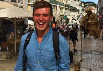 Adrian smiling for a photo on a busy street