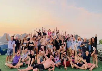 A group of travelers posing in front of a sunset