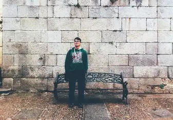 Carlos posing at a bench