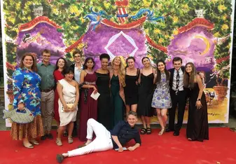 Alexa poses with friends in front of a colorful backdrop