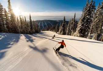 Skier on morning run, empty slopes