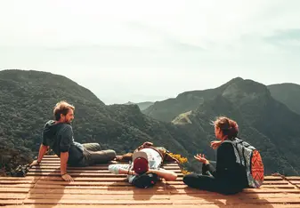 Three friends sitting in the mountains.