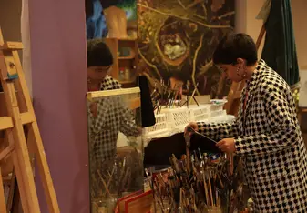 Student looking at paint brushes in class