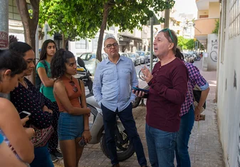 A professor explains a concept to students while on a tour of Tel Aviv