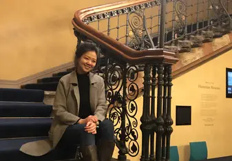 Eryn Lin smiling sitting on a staircase
