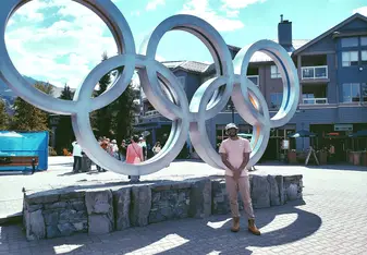 Jonas Hudnall standing in front of the Olympics sign 