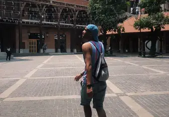 Jonas Hudnall walking with a baseball cap and backpack