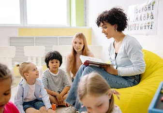 Woman reading to young children.