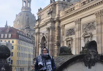 Kania Putri P wearing a scarf and glasses smiling