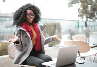 An online ESL teacher giving a lesson on her laptop outside