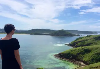 Amy Krzyzek standing in front of a seaside view with mountains in the distance