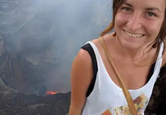 Emily Miller standing at the top of a volcano smiling 