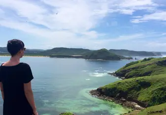 Amy Krzyzek standing in front of a seaside view with mountains in the distance
