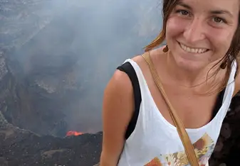 Emily Miller standing at the top of a volcano smiling 