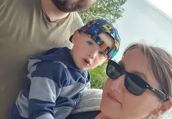 Jacob Thamas with his wife and son with the ocean in the background