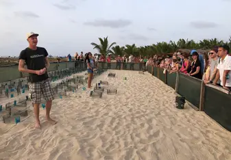 A Project Biodiversity group on a beach with a volunteer coordinator talking