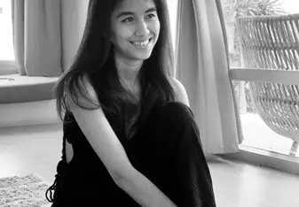INTAN STEFHANIE wearing a black jumpsuit with long dark hair and smiling