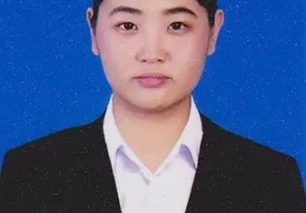 Tang with a white button up shirt, black blazer, and dark hair tied in a bun