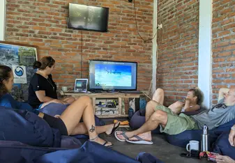Helen Wu sitting with other volunteers watching an informational video