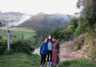 3 students standing in front of hills