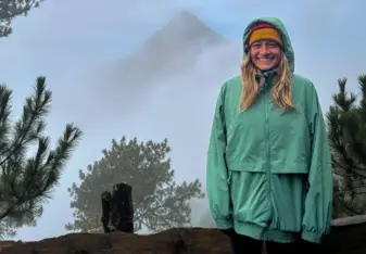 Volunteer smiling in front of a volcano