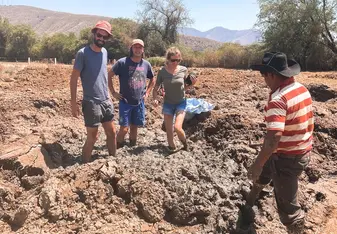 3 students preparing the mud to make adobe bricks