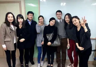 A teacher poses with a group of smiling students.