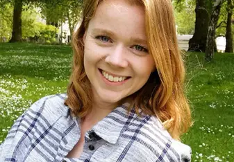Sarah Butler with red hair and a flannel shirt