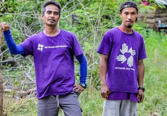 two volunteers in the Philippines standing in grassy field