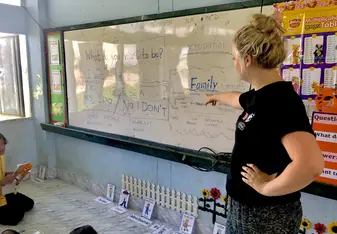 Teacher pointing to white board