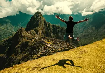 A man jumps in the air near Machu Picchu
