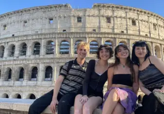 Students smiling in front of colosseum