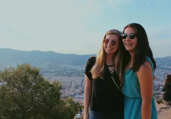 Friends abroad posing for a picture with a scenic background 