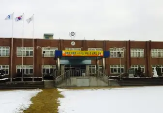 A typical public (government) school in South Korea, you’ll find they almost all have the same facade, right down to the clock, placement of flags and even the sculptures!