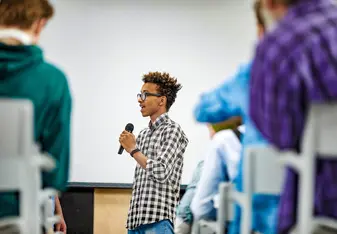 A student speaking through a microphone